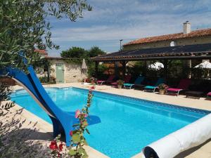 ein Pool mit blauer Rutsche neben einem Haus in der Unterkunft La Pommeraie in Nantillé