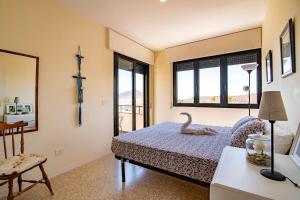 a bedroom with a bed with a swan on it at Alquilaencanarias- Medano spectacular terrace and sea views B in El Médano
