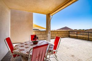 a table and chairs on a balcony with a view at Alquilaencanarias- Medano spectacular terrace and sea views B in El Médano