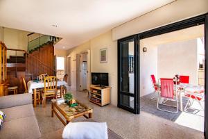 a living room with a couch and a dining room at Alquilaencanarias- Medano spectacular terrace and sea views B in El Médano