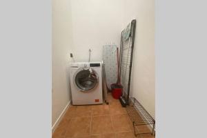 una lavanderia con lavatrice e pavimento piastrellato di 6.4.6 - Via Jodi 6 a Reggio Emilia