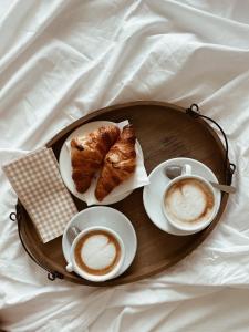 a tray with pastries and cups of coffee on a bed at Art Hotel Pietrasanta in Pietrasanta +116 photos