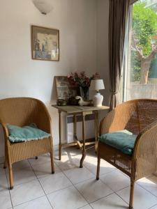 Habitación con 2 sillas y mesa con ventana en Villa Soraya , quiet location with big garden near beach and old town of NICE, en Niza