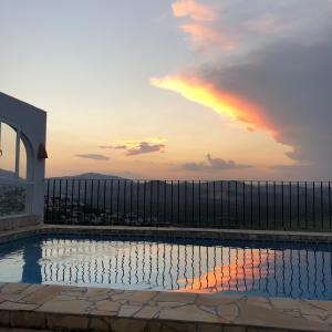 a view of a pool with a rainbow in the sky at Villa Luz del Monte in Denia