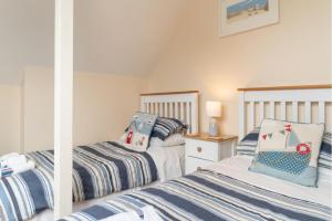 a bedroom with two beds and a mirror at Number 9 Rosemorran in St Ives
