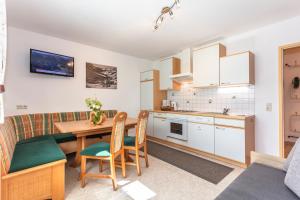 a kitchen and living room with a table and a couch at Haus Schwaighofer in Saalbach Hinterglemm