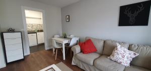 - un salon avec un canapé et une table dans l'établissement Apartamento playa San Lorenzo, à Gijón