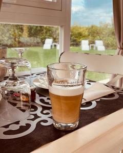 un bicchiere di birra seduto su un tavolo di fronte a una finestra di Corte Caselle a Sommacampagna