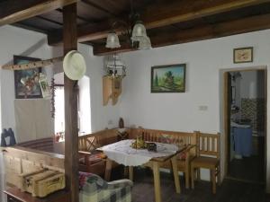 Traditionelles Bauernhaus Flieder في Zalaszentgrót: مطبخ وغرفة طعام مع طاولة وكراسي