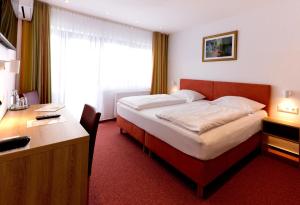 a hotel room with a bed and a desk and a desk at Mariaweiler Hof in Düren - Eifel