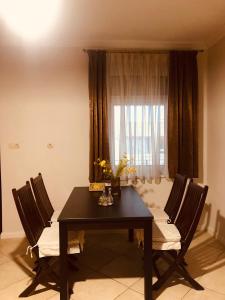 a dining room table with two chairs and a window at Apartman Tapolca Belváros in Tapolca
