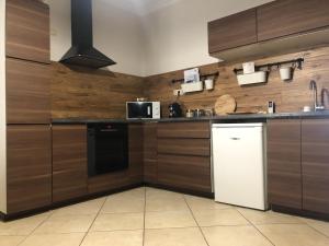 a kitchen with wooden cabinets and a white refrigerator at Apartman Tapolca Belváros in Tapolca