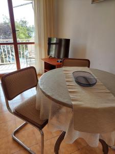 a table and chairs in a room with a television at Villa Meri in Prizba