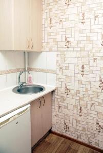 uma casa de banho com um lavatório e uma parede em azulejo em Apartment on Frunze 15 em Dnipro