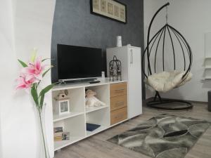 un soggiorno con un centro di intrattenimento bianco con televisore di APARTMENTS IVANOViC a Bajina Bašta