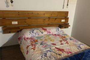 uma cama com uma cabeceira em madeira num quarto em Estudio Pajar rural con bonito jardín - Los Gayoles Rural em Castropol