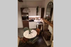 een keuken met een tafel en stoelen en een fornuis bij Le repaire malouin in Saint-Malo