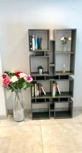 a gray book shelf with flowers in a vase at Millstream Mews in Bakewell