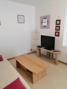 a living room with a television and a coffee table at Gîte en Brenne Les Chênes in Mérigny