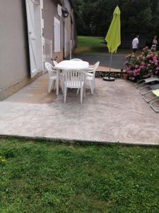 a patio with a table and chairs and an umbrella at Gîte en Brenne Les Chênes in Mérigny