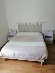 1 dormitorio con 1 cama blanca y 2 mesitas de noche en Gîte en Brenne Les Chênes, en Mérigny