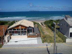 a building on the beach next to the ocean at Suítesmariscal Suítes Mariscal in Bombinhas