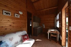 a living room of a log cabin with a couch at Villaggio Gofree in Pragelato