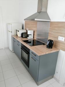 a kitchen with a stove top oven next to a refrigerator at Gîte en Brenne Les Chênes in Mérigny