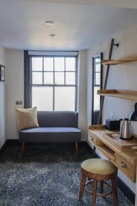 a living room with a blue couch and a desk at The Turks Head in Exeter