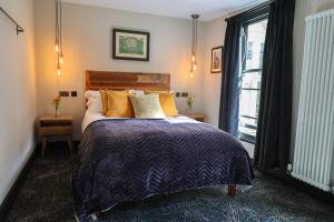 a bedroom with a bed with orange pillows and a window at The Turks Head in Exeter