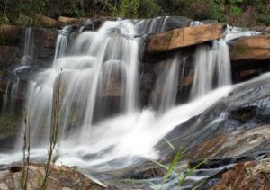 a waterfall in the middle of a river at Pousada Fazenda das Bicas in Andrelândia