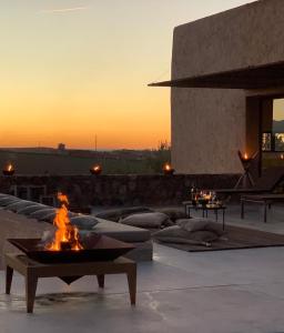 a fire pit on a patio with a sunset in the background at Villa K in Marrakech