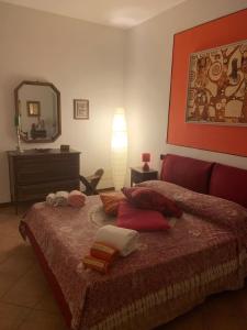 a bedroom with a bed with pillows and a mirror at VILLA STELLA in Montalcino