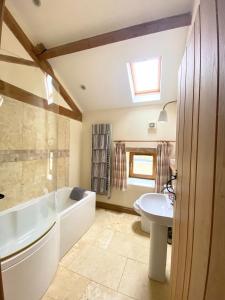 a bathroom with a tub and a sink and a bath tub at The Barn in Bedale +33 photos