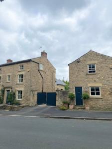 un vieux bâtiment en briques avec une porte bleue dans une rue dans l'établissement The Barn, à Bedale