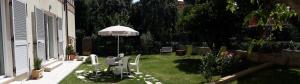 a patio with an umbrella and chairs in a yard at Le Pecore di Terracotta in Pesaro