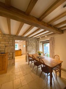 uma cozinha e sala de jantar com uma mesa de madeira e cadeiras em The Barn em Bedale