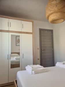a bedroom with a white bed and a mirror at Hello Sunshine - Apartment on the Beach in Zubovići
