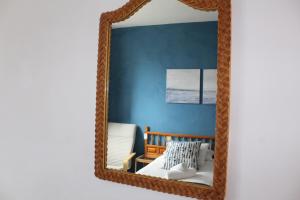 espejo con marco de madera en la pared en Apartamentos Playa, en Hermigua