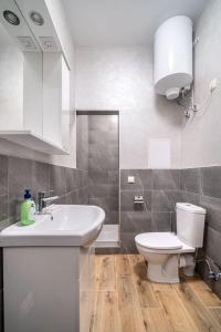 een badkamer met een witte wastafel en een toilet bij Boomerang apart-apart hotel in Kolomiya