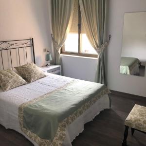 um quarto com uma cama grande e uma janela em El Mirador de la Villa em Puebla de Sanabria