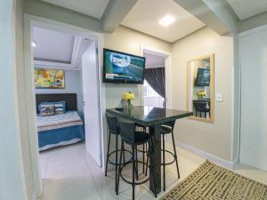 a small kitchen with a bar in a room with a bed at Apartamento Pontal Norte Ao Lado Da Big Wheel in Balneário Camboriú