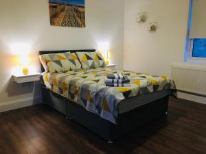 a bedroom with a bed with a yellow and blue comforter at Keanes Country Cottage in The Heart Of The West in Lisacul