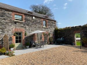 a brick house with a patio with an umbrella at Period Coachhouse in Newbliss