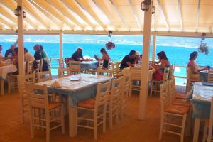 a group of people sitting at tables in a restaurant at Giota Studios in Ammouliani