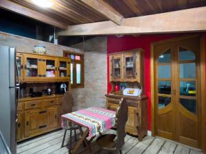 a kitchen with wooden cabinets and a table and a refrigerator at Casa Refúgio Cantareira in Mairiporã