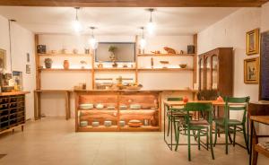 a kitchen with green chairs and a table and shelves at Cotton Loft in Alba Iulia