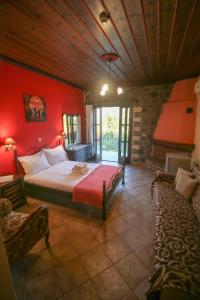 sypialnia z czerwonymi ścianami, łóżkiem i kanapą w obiekcie Konitsa Panorama w mieście Konitsa