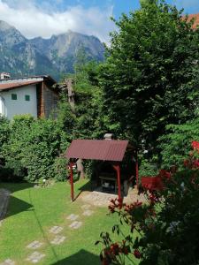 a garden with a bench and a red roof at Casa Riciu in Buşteni