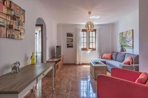 sala de estar con sofá azul y sillas rojas en Agora - Spacious apartment 2 bedrooms- 2 bathrooms, en Puerto de la Cruz